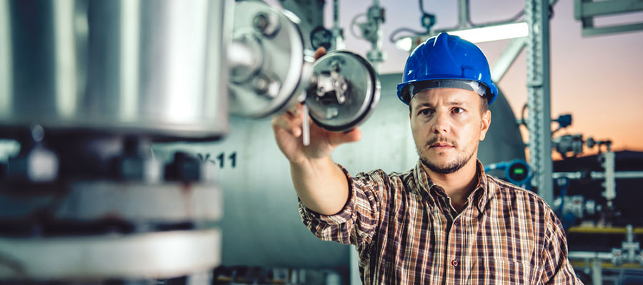 man examining chemical tanks